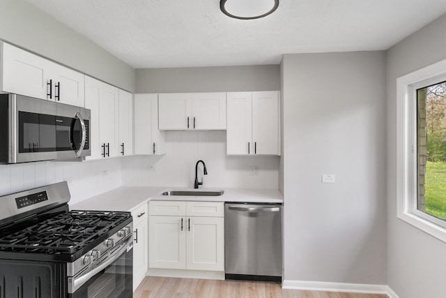 505 Barbara Ct, University Park, IL 60484 - kitchen featuring stainless steel appliances, light countertops, light wood-style flooring, white cabinetry, and healthy amount of natural light