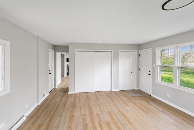 505 Barbara Ct, University Park, IL 60484 - unfurnished bedroom with a baseboard heating unit, two closets, light wood-style flooring, and baseboards