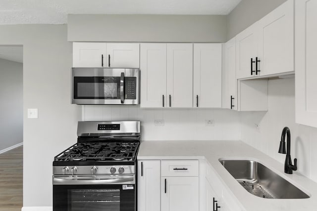 505 Barbara Ct, University Park, IL 60484 - kitchen featuring appliances with stainless steel finishes, a sink, decorative backsplash, and white cabinets