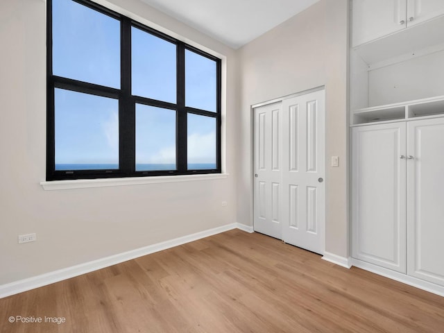 1464 S Michigan Ave Unit 2201, Chicago, IL 60605 - unfurnished bedroom featuring baseboards, light wood-type flooring, and a closet