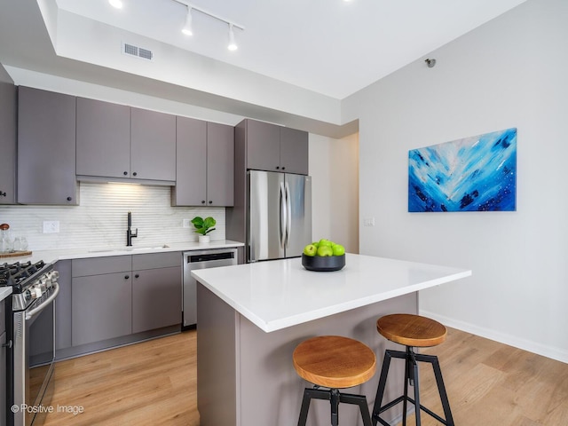 1464 S Michigan Ave Unit 2201, Chicago, IL 60605 - kitchen featuring stainless steel appliances, a sink, light wood-style floors, a kitchen bar, and gray cabinets