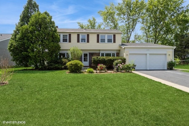 679 Aspen Dr, Buffalo Grove, IL 60089 - colonial house featuring asphalt driveway, an attached garage, and a front lawn
