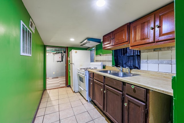 2807 S Spaulding Ave, Chicago, IL 60623 - kitchen featuring white appliances, light tile patterned floors, a sink, light countertops, and ventilation hood