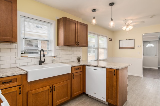 6136 N Nagle Ave, Chicago, IL 60646 - kitchen with white dishwasher, a sink, a peninsula, and brown cabinetry