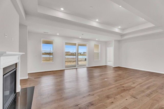 3245 Lincoln Prairie Blvd, Aurora, IL 60503 - unfurnished living room with a tray ceiling, a fireplace, light wood-type flooring, baseboards, and recessed lighting