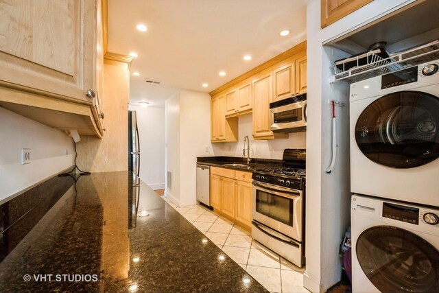 4148 N Clarendon Ave Unit 102, Chicago, IL 60613 - kitchen featuring stainless steel appliances, stacked washer / drying machine, light brown cabinets, dark stone counters, and recessed lighting