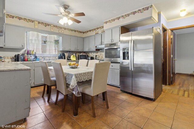 611 Palace St, Aurora, IL 60506 - kitchen featuring stainless steel appliances, gray cabinets, a ceiling fan, light countertops, and under cabinet range hood