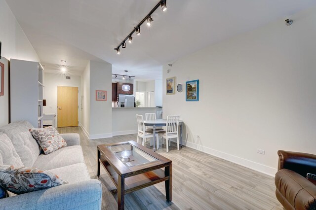 125 S Green St Unit 705A, Chicago, IL 60607 - living area featuring rail lighting, light wood-style floors, and baseboards