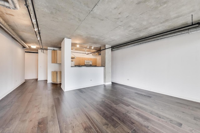 700 W Van Buren St Unit 1301, Chicago, IL 60607 - unfurnished living room featuring dark wood-style floors, baseboards, and a garage