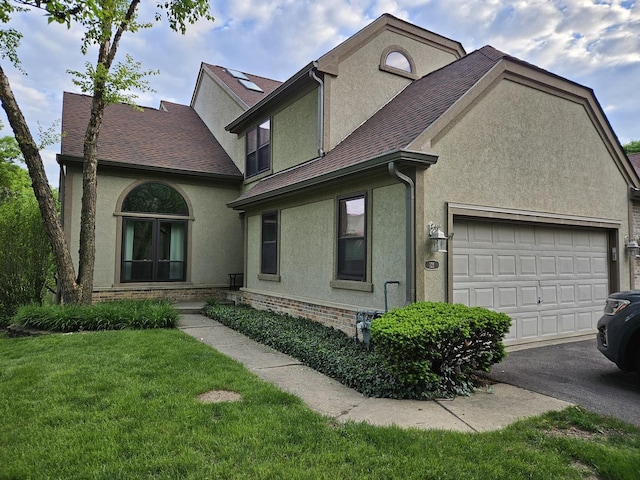 121 Chatsworth Cir, Schaumburg, IL 60194 - view of front facade with stucco siding, asphalt driveway, a front lawn, and an attached garage
