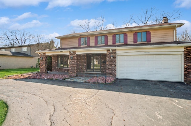 20832 Sparta Ln, Olympia Fields, IL 60461 - view of front of property with asphalt driveway, a chimney, brick siding, a garage, and a porch