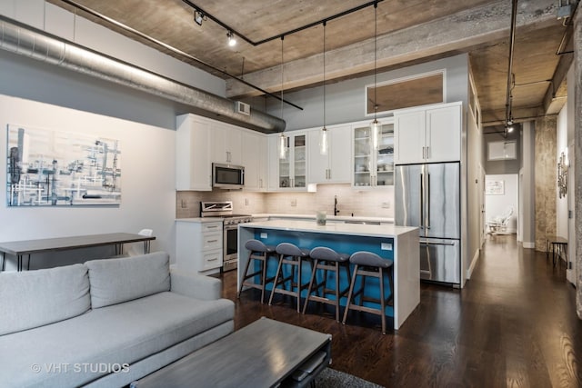 843 W Adams St Unit 310, Chicago, IL 60607 - kitchen with stainless steel appliances, a breakfast bar area, glass insert cabinets, dark wood finished floors, and a center island