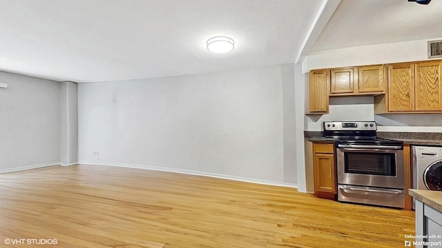1567 Ridge Ave Unit 307, Evanston, IL 60201 - kitchen featuring electric stove, washer / dryer, light wood-style flooring, and dark countertops