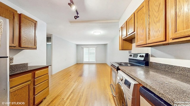 1567 Ridge Ave Unit 307, Evanston, IL 60201 - kitchen featuring stove, light wood finished floors, dark countertops, brown cabinetry, and rail lighting