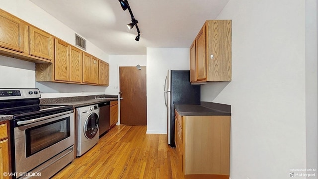 1567 Ridge Ave Unit 307, Evanston, IL 60201 - kitchen featuring appliances with stainless steel finishes, washer / dryer, dark countertops, light wood-style floors, and rail lighting