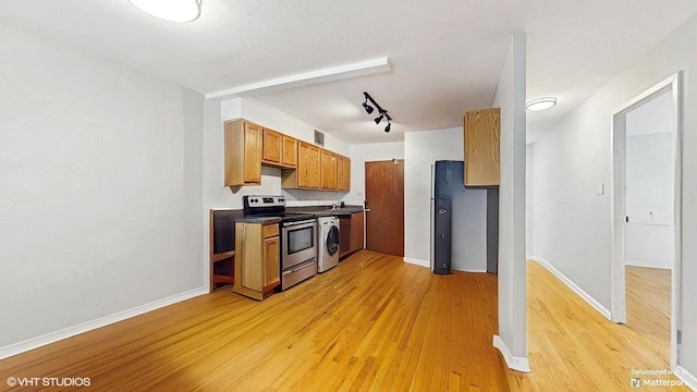 1567 Ridge Ave Unit 307, Evanston, IL 60201 - kitchen with stainless steel electric range, light wood-type flooring, brown cabinetry, dark countertops, and washer / dryer