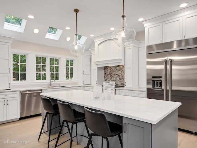 1360 Turvey Rd, Downers Grove, IL 60515 - kitchen featuring appliances with stainless steel finishes, white cabinetry, a skylight, light countertops, and decorative backsplash