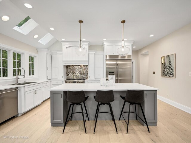 1360 Turvey Rd, Downers Grove, IL 60515 - kitchen featuring appliances with stainless steel finishes, a skylight, backsplash, white cabinetry, and recessed lighting