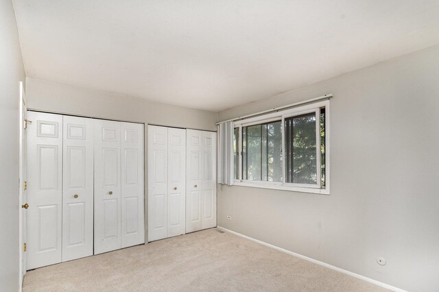 2265 Windsor Ln, Country Club Hills, IL 60478 - unfurnished bedroom featuring multiple closets, carpet, and baseboards