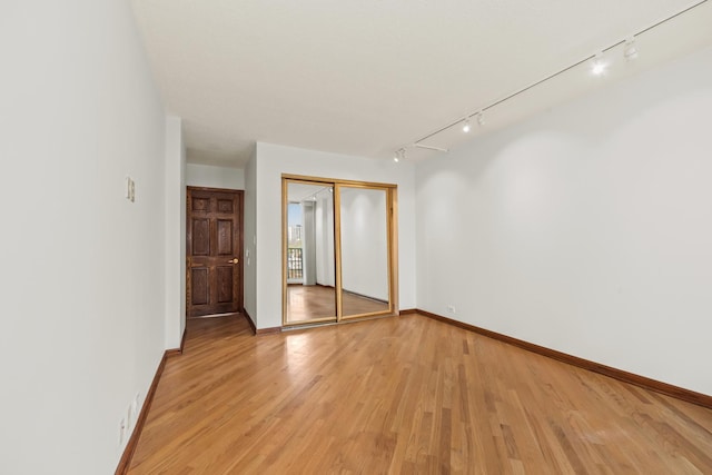 4170 N Marine Dr Unit 6L, Chicago, IL 60613 - unfurnished bedroom with rail lighting, a closet, light wood-style floors, and baseboards