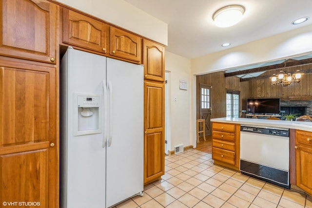 9445 Le Claire Ave, Skokie, IL 60077 - kitchen featuring white appliances, brown cabinets, light countertops, light tile patterned floors, and wooden walls
