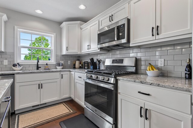 1607 Peppermill Ln, Champaign, IL 61822 - kitchen featuring stainless steel appliances, white cabinets, backsplash, light stone counters, and recessed lighting