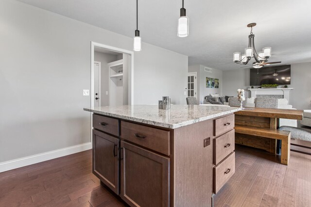 1607 Peppermill Ln, Champaign, IL 61822 - kitchen with dark wood finished floors, light stone counters, open floor plan, and decorative light fixtures