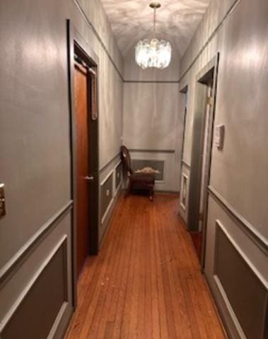 hallway with a chandelier and light wood-style flooring