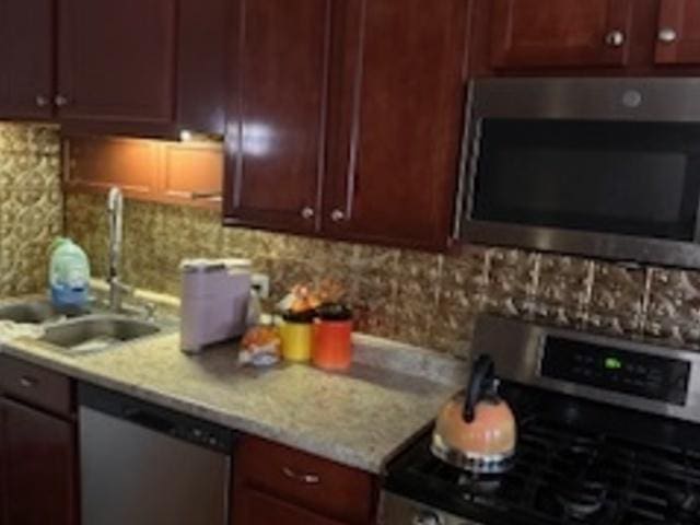 kitchen with stainless steel appliances and backsplash