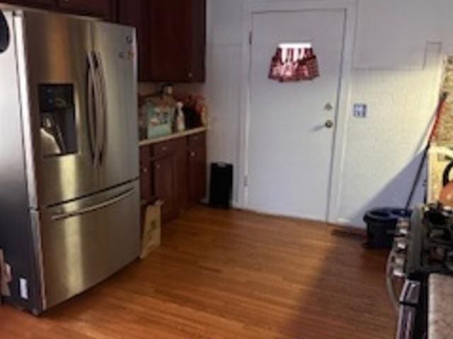 kitchen featuring stainless steel fridge, light wood-type flooring, and light countertops