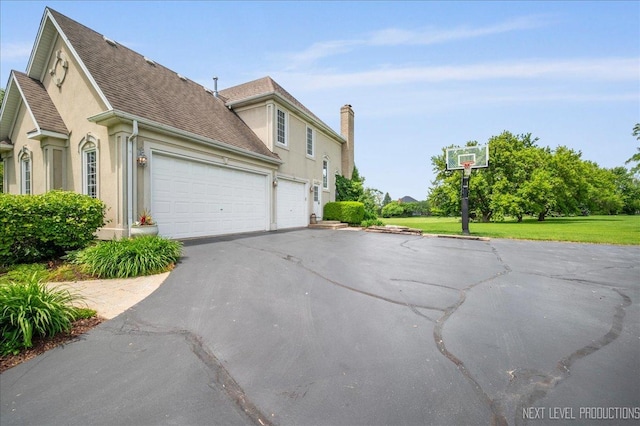 36W850 Red Gate Ct, Saint Charles, IL 60175 - view of property exterior featuring stucco siding, asphalt driveway, an attached garage, and a chimney