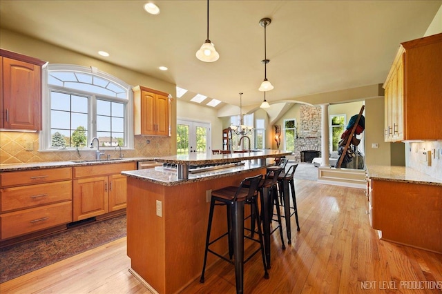 36W850 Red Gate Ct, Saint Charles, IL 60175 - kitchen featuring a sink, a breakfast bar area, light wood finished floors, tasteful backsplash, and open floor plan