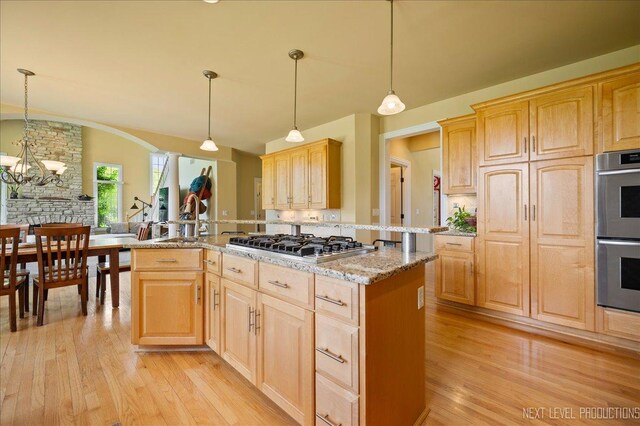 36W850 Red Gate Ct, Saint Charles, IL 60175 - kitchen with stainless steel appliances, light brown cabinets, light wood-style floors, light stone counters, and a chandelier