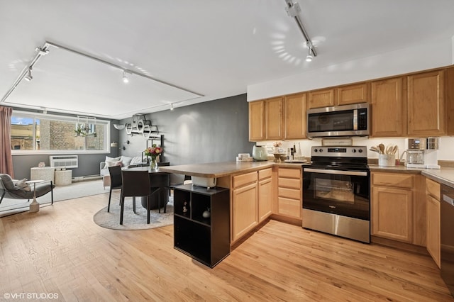 5854 N Kenmore Ave Unit 4F, Chicago, IL 60660 - kitchen with stainless steel appliances, rail lighting, open floor plan, a peninsula, and light wood finished floors