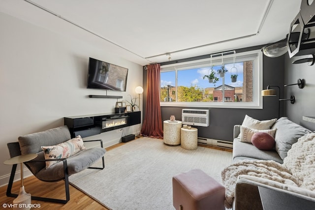 5854 N Kenmore Ave Unit 4F, Chicago, IL 60660 - living area featuring wood finished floors, an AC wall unit, baseboards, baseboard heating, and a glass covered fireplace
