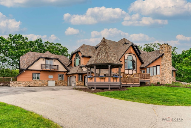 20719 Highview Rd, Marengo, IL 60152 - view of front of home featuring stone siding, a front lawn, a balcony, driveway, and roof with shingles