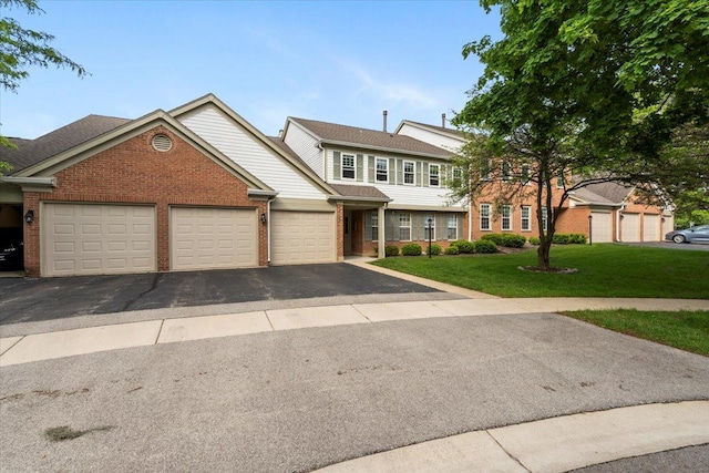 1300 Woodside Ct Unit B2, Schaumburg, IL 60193 - townhome / multi-family property with a garage, brick siding, asphalt driveway, and a front yard