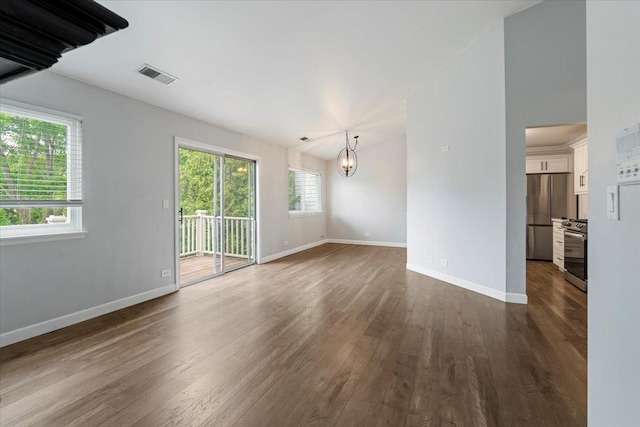 1300 Woodside Ct Unit B2, Schaumburg, IL 60193 - empty room featuring a chandelier, plenty of natural light, dark wood finished floors, and baseboards
