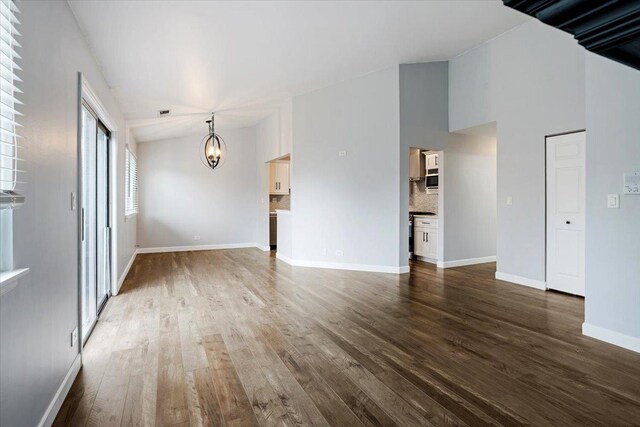 1300 Woodside Ct Unit B2, Schaumburg, IL 60193 - unfurnished living room featuring a chandelier, dark wood-type flooring, and baseboards