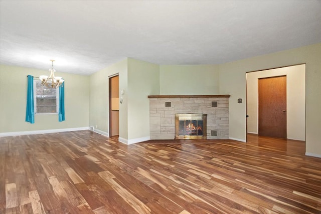 2906 Bethel Blvd, Zion, IL 60099 - unfurnished living room with a chandelier, wood finished floors, baseboards, and a stone fireplace