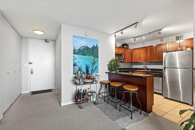 655 W Irving Park Rd Unit 4212, Chicago, IL 60613 - kitchen featuring appliances with stainless steel finishes, dark countertops, a breakfast bar area, a peninsula, and brown cabinets