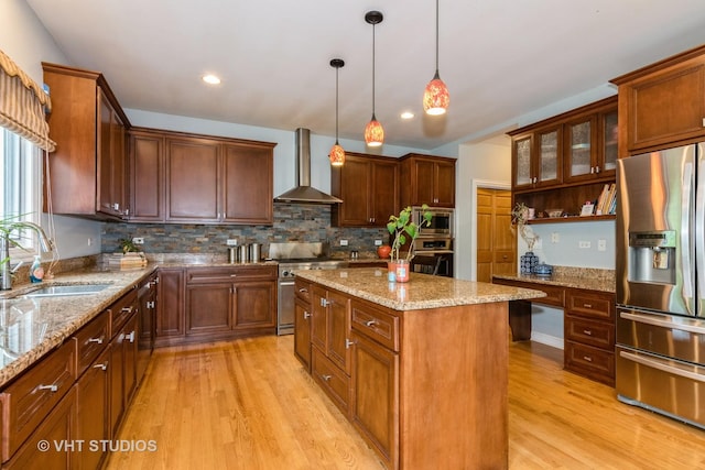 316 Juliana Ln, Bloomingdale, IL 60108 - kitchen with appliances with stainless steel finishes, wall chimney exhaust hood, a sink, light wood-type flooring, and a center island