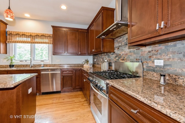 316 Juliana Ln, Bloomingdale, IL 60108 - kitchen featuring appliances with stainless steel finishes, wall chimney exhaust hood, a sink, light stone countertops, and light wood-style floors