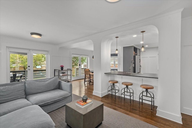 2087 W Greenleaf Ave, Chicago, IL 60645 - living area with french doors, dark wood-type flooring, ornamental molding, arched walkways, and baseboards