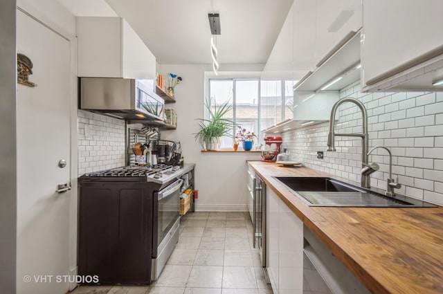 932 W Sunnyside Ave Unit 3C, Chicago, IL 60640 - kitchen featuring wooden counters, gas stove, a sink, white cabinetry, and light marble finish floors