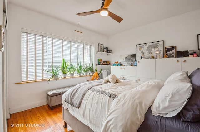 932 W Sunnyside Ave Unit 3C, Chicago, IL 60640 - bedroom featuring wood finished floors, baseboards, radiator heating unit, and a ceiling fan