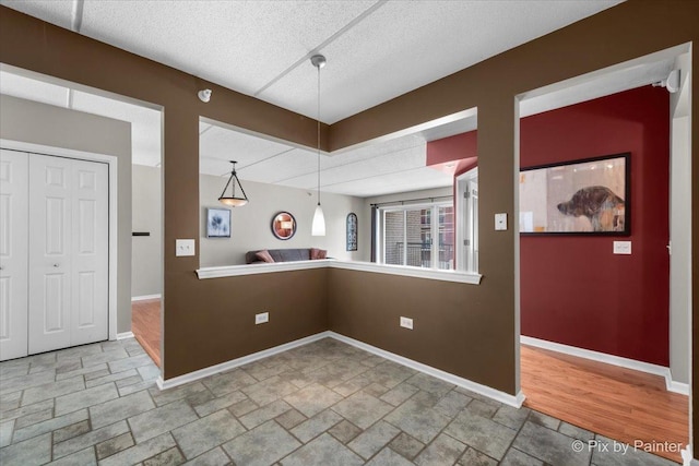 1327 Brown St Unit 206, Des Plaines, IL 60016 - kitchen featuring stone tile floors, baseboards, a textured ceiling, and pendant lighting