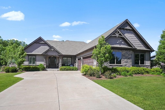 5949 Whitetail Ridge Dr, Yorkville, IL 60560 - craftsman-style house with stone siding, a garage, concrete driveway, and a front yard