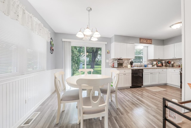 201 N First St, Wilmington, IL 60481 - dining space featuring plenty of natural light, a chandelier, light wood finished floors, and wainscoting