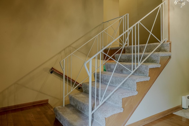 staircase featuring hardwood / wood-style floors and baseboards